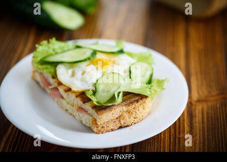 Panino con salsiccia e formaggio, lattuga e uova Foto Stock