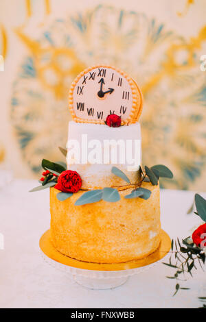 Torta nuziale decorata con orologi e fiori close up Foto Stock