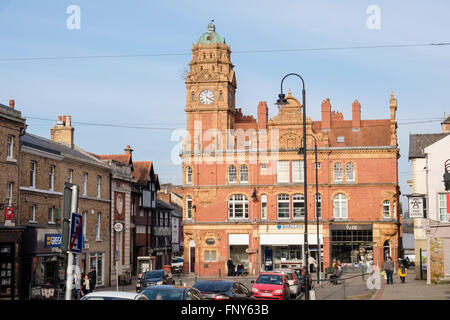 Vista lungo High Street a vecchio orologio tower edificio nel centro della città. Newtown, Powys, metà del Galles, Regno Unito, Gran Bretagna Foto Stock