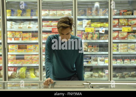 Supermercato Carrefour cliente in cerca in un congelatore di alimenti congelati sezione. Foto Stock