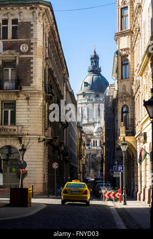 Budapest, Ungheria - 14 Marzo 2016: Yellow taxi la guida verso la Basilica di Santo Stefano su Lazar street a Budapest, Ungheria Foto Stock