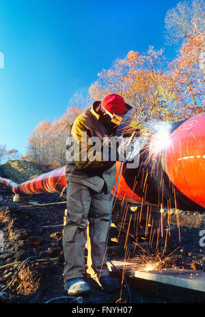 L'uomo la saldatura di una giunzione di pipeline nelle zone rurali del West Virginia; USA Foto Stock