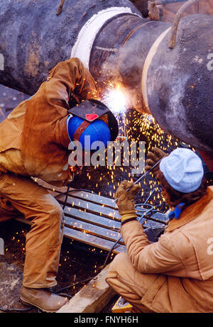 L'uomo la saldatura di un gasdotto cucitura per l'installazione sotto il Fiume Delaware; Pennsylvania rurale; USA Foto Stock