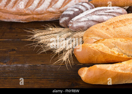 Varie lievitato di grano intero e di pasta acida pane bianco focacce con steli di grano sul tavolo Foto Stock