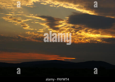 Sunset Shasta Valley, California, USA, vista del bellissimo cielo subito dopo il tramonto, nero gamme della montagna , giallo arancio nuvole Foto Stock