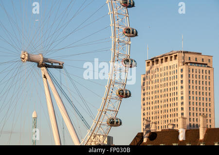 Il London Eye ruota panoramica sul cielo azzurro e la Shell di edificio in background, Londra UK. Foto Stock