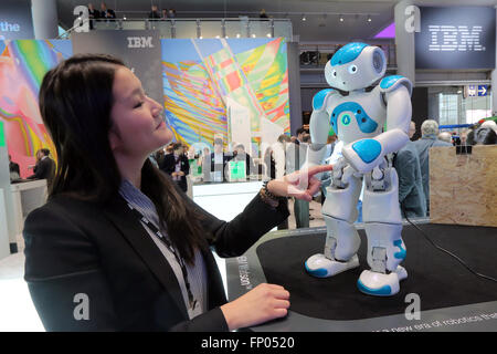 Uno stand hostess tocca un NAO robot Watson presso la IBM stand al CeBIT 2016 tecnologia digitale fiera di Hannover in Gerrmany Foto Stock