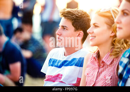 Gli adolescenti presso i festival estivi di musica, seduto a terra Foto Stock
