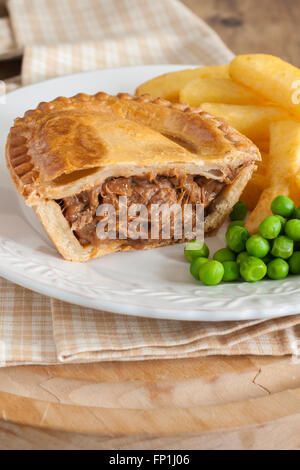 Bistecca di manzo o torta con patatine o patate fritte e piselli verdi Foto Stock