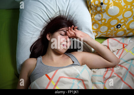 Stanco della donna dormire su un letto di casa Foto Stock