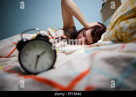 Donna con insonnia di toccare la sua testa Foto Stock