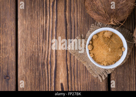 Lo zucchero di cocco (messa a fuoco selettiva) sull'annata sullo sfondo di legno Foto Stock