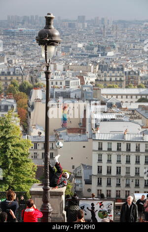 Prestazioni acrobatiche artista a una vecchia lampada a gas sulla collina del Sacre Coeur di Montmartre Parigi Foto Stock