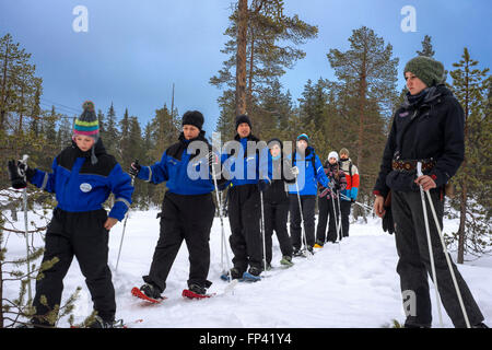 Gruppo di turisti a Salla facendo una gita con le racchette da neve a parete di ghiaccio, Salla, Lapponia, Finlandia. È possibile vivere la natura invernale anche Foto Stock