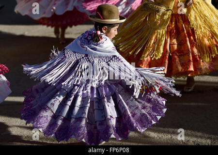 L Aymara ragazza ballare al Festival di La Virgen del Rosario in provincia di Chucuito, Regione di Puno, Perù. La Virgen del Rosario è il santo patrono dell'Ordine Domenicano, che erano in carica delle confraternite slave in tempi coloniali. La celebrazione è evidenziata dalla presenza di pallas, signore vestito in costume con maniche larghe e alte corone di fiori e il famoso negritos, danzatori vestiti di lana nera maschere che animano la celebrazione. Foto Stock