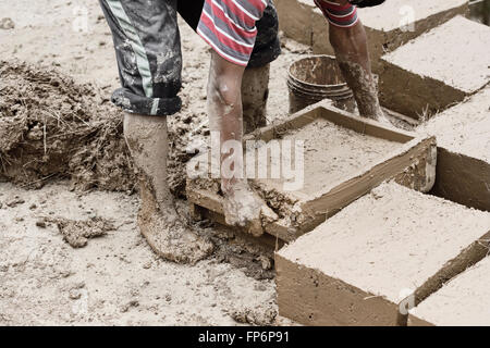 Ragazzo che adobe tradizionali mattoni di fango per costruire la propria casa in Parù Parù villaggio comunità, Pisaq distretto, regione di Cusco, Perù. Foto Stock