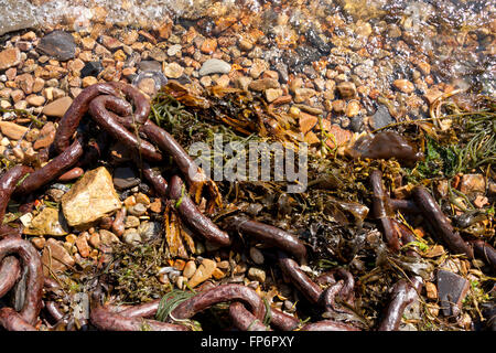 Rusty nave della catena su una spiaggia ghiaiosa Foto Stock