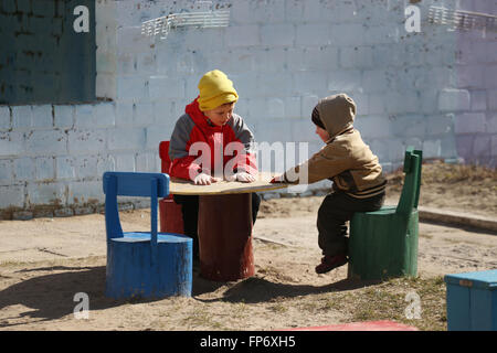 I bambini giocano nel parco giochi. inizio primavera Foto Stock