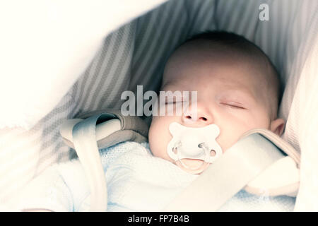 3 mesi baby boy dormire nel suo passeggino una giornata di sole Foto Stock