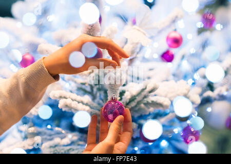 La donna a casa decorazione albero di Natale. Close-up le mani Foto Stock