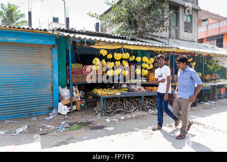 Pressione di stallo di frutta su strada in Maduranthakam, Kancheepuram distretto del Tamil Nadu, con 2 persone locali ragazzi camminare davanti a parlare Foto Stock