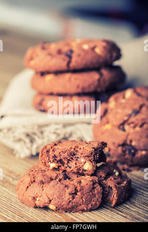 Biscotti al cioccolato i cookies. Biscotti al cioccolato sulla biancheria da letto bianca igienico sul tavolo di legno. Foto Stock
