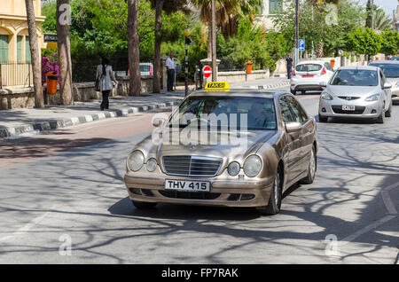 Taxi Mercedes guidando lungo una strada nella città di Kyrenia, la parte settentrionale di Cipro. Foto Stock