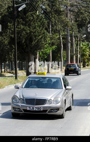 Taxi Mercedes guidando lungo una strada nella città di Kyrenia, la parte settentrionale di Cipro. Foto Stock