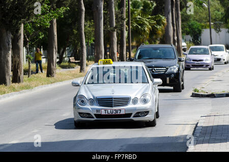 Taxi Mercedes guidando lungo una strada nella città di Kyrenia, la parte settentrionale di Cipro. Foto Stock