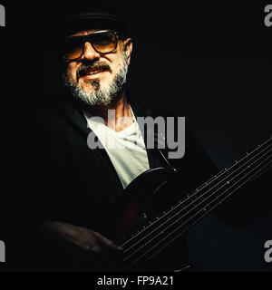 Ritratto di un vecchio musicista a suonare il basso con cinque stringhe. Foto Stock