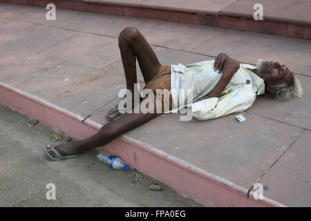 Senzatetto uomo dorme sulla strada di Agra Foto Stock