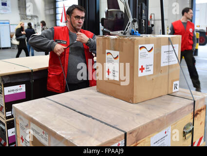 Membro dello staff della Croce Rossa tedesca (DRK), Jens Hunlat, fissa la paura di un carrello che trasporta di forniture di soccorso in Schoenefeld, Germania, 18 marzo 2016. La DRK invia un medico di base station per fornire aiuto medico per circa diecimila persone per la regione intorno a Idomeni nella Grecia settentrionale. Foto: Bernd Settnik/dpa Foto Stock