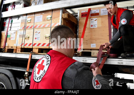 I membri dello staff della Croce Rossa tedesca (DRK) fissano la paura di un carrello che trasporta di forniture di soccorso in Schoenefeld, Germania, 18 marzo 2016. La DRK invia un medico di base station per fornire aiuto medico per circa diecimila persone per la regione intorno a Idomeni nella Grecia settentrionale. Foto: Bernd Settnik/dpa Foto Stock