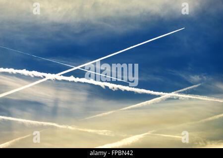 Attraversato contrails nel cielo con due battenti passato aeroplani Foto Stock