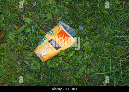 Spazzatura stradale, McDonalds contenitore per bevande, schiacciato adn sinistra in erba compagnia sulla strada. Foto Stock