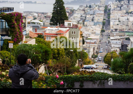 Uomo Uomo cattura la cattura di San Francisco dal Lombard Street. Foto Stock