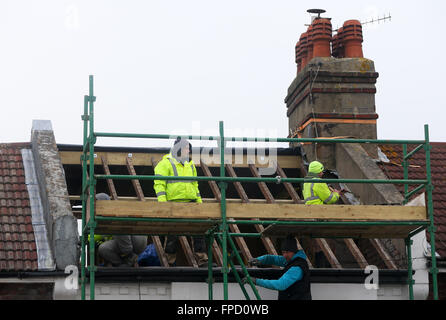 Costruttori la rimozione di un tetto per costruire un soppalco conversione su un vittoriano proprietà terrazzati. Foto Stock