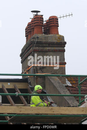 Costruttori la rimozione di un tetto per costruire un soppalco conversione su un vittoriano proprietà terrazzati. Foto Stock