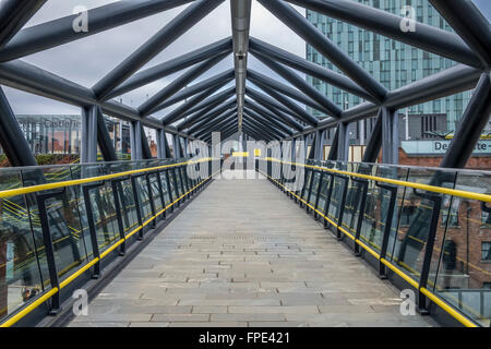 Overhead pedonale passerella tra Deansgate treni e tram di Deansgate Station. Foto Stock