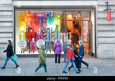 Guardando verso il basso gli acquirenti fuori dal colorato negozio invernale vetrina dello shopping in un negozio di abbigliamento uni Qlo a Regent Street Londra Inghilterra Regno Unito Foto Stock