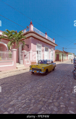 TRINIDAD, CUBA - MARZO 30, 2012: Chevrolet Vintage giallo auto vicino a Colonial case colorate della città vecchia Foto Stock