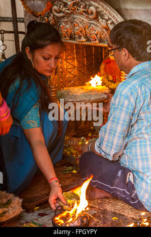 Il Nepal, Patan. La presentazione di offerte presso un tempio indù santuario. Foto Stock