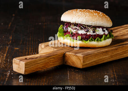 Burger di barbabietole con formaggio morbido e germogli di rafano su sfondo scuro Foto Stock