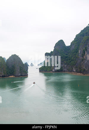 Vista della spettacolare e misteriosa Baia di ha Long, Vietnam. La baia è punteggiata da strane isole calcaree UN'unica barca Foto Stock