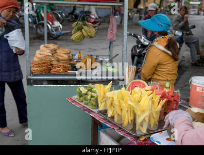 Hoi An,Vietnam, Donna marciapiede venditore a vendere frutta fresca in una bancarella di strada in Hoi An. Cucina di strada è importante in Vietnam Foto Stock