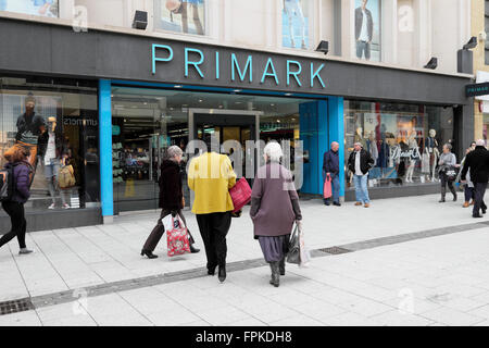 Vista posteriore delle donne per gli acquirenti all'esterno dell'ingresso di Un cartello con la scritta Primark Store su Queen Street nella città di Cardiff Centro Galles Regno Unito KATHY DEWITT Foto Stock