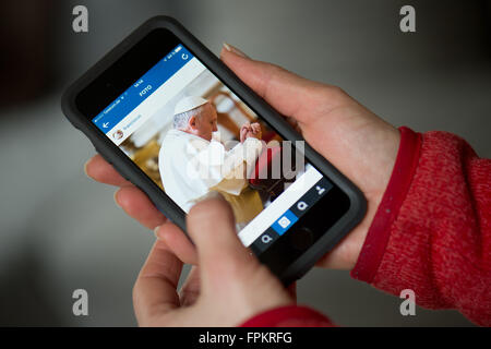 Papa Francesco, Dresda, Germania. Xix Mar, 2016. Illustrazione - Una donna tenendo un smartphone che mostra la Instagram conto del Papa Francesco, Dresda, Germania, 19 marzo 2016. Il papa inizia la condivisione di foto e video di breve durata con utenti di tutto il mondo utilizzando il nome account "Franciscus', la versione latina del suo nome. Foto: ARNO BURGI/dpa/Alamy Live News Foto Stock