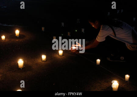 Manila, Filippine. Xix Mar, 2016. Una ragazza accende una candela come lei partecipare a luce di candela e attività di preghiera a San Agustin Chiesa come il contattore luci-off per Earth Hour 2016. Ora della Terra è un evento internazionale organizzato dal World Wildlife Fund for Nature che incoraggiare le persone, le comunità e le imprese a un'ora luci-off come un impegno a fermare il cambiamento climatico. © Marlo Cueto/Pacific Press/Alamy Live News Foto Stock