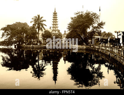 Età e oscurata la visuale globale Buddist Tran Quoc Pagoda e il tempio di fronte Ho Tay Lake in una nebbiosa giornata di gennaio,Hanoi, Vietnam. Foto Stock