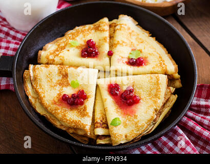 Golden frittelle con marmellata di mirtilli e miele in uno stile rustico. Vista superiore Foto Stock